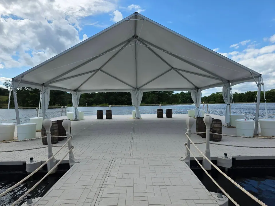 Rope-lined dock approach leading onto the floating event pavilion beneath its white tent at Big Prairie
