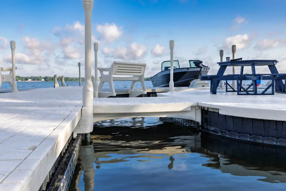 Wave Armor modular floating dock platform Connected Wave Armor floating dock sections with a corner platform, dock posts, and seating beside the water