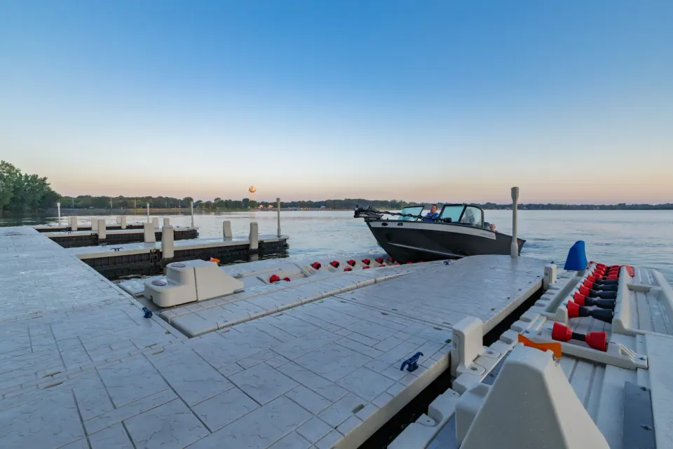Wave Armor waterfront dock with boat and PWC ports Wave Armor floating dock with a boat and PWC ports on the water at sunset
